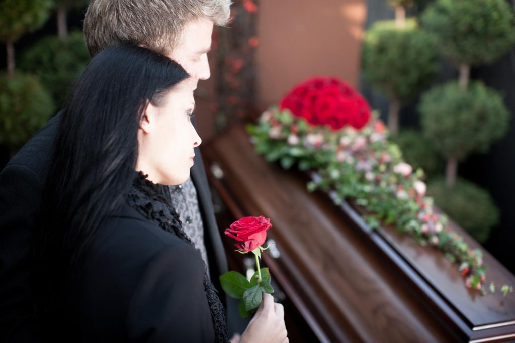 deux personnes devant un cercueil